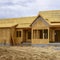 Square Facade of home under construction against snowy mountain and cloudy sky