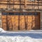 Square Facade of a luxury wooden home in Park City Utah with snowy driveway in winter