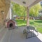 Square Fenced backyard of a house with sliding glass back door and large green lawn