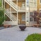 Square Fire pit with stone benches against building with yellow brick wall and stairs