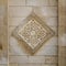 Square floral pattern unit carved into exterior stone wall of Al Hakim Mosque, Old Cairo, Egypt