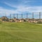 Square Focus on a sand trap surrounded by short green grasses at a sunny golf course