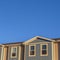 Square Focus on the upper storey of townhomes with blue sky background on a sunny day