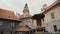 Square with fountain in courtyard inside Cesky Krumlov castle. Medieval tower