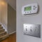 Square frame Air conditioning control panel and light switches mounted on a white wall