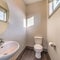 Square frame Bathroom of home with free standing sink round mirror toilet and wooden floor