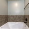 Square frame Bathroom interior with drop in tub with brown tile surround