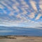 Square frame Boundless blue sky with gray and white clouds over a vast sandy shore