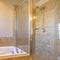 Square frame Built in gleaming bathtub inside the warm toned bathroom of a new house