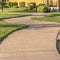 Square frame Close up of narrow paved pathway winding through lush grasses on a sunny day