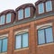 Square frame Close up of upper exterior of a building with red brick wall and attic windows