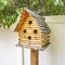 Square frame Close up of wooden birdhouse with several entrance holes at the yard of a home