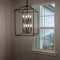Square frame Geometric chandelier hanging from the ceiling of home against window and wall
