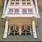 Square frame Home with cottage pane windows and gable roof viewed from below against sky