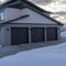 Square frame Home exetrior with paved driveway leading to the three door garage entrance