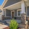 Square frame Home facade with view of yard and gable roofs over garage and front porch