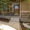 Square frame Home facade with view of yard garage door porch and front door on a sunny day