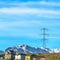 Square frame Homes with snow covered mountain and electricity tower in the background