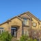 Square frame House with stairs on the landscaped yard leading to the wrought iron front door