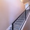 Square frame Indoor staircase against brown wooden floor and plain white wall of home