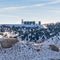 Square frame Industrial building on top of a rugged snowy mountain against cloudy sky