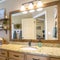 Square frame Interior of home bathroom with vanity area and toilet against beige wall