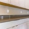 Square frame Kitchen interior of a house with white cabinets below the gleaming countertop