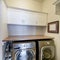 Square frame Laundry room with stainless laundry machines below the wooden desk