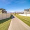 Square frame Long pedestrian walkway between walled houses during day