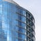 Square frame Moden building with glass walls and balconies viewed against cloudy blue sky