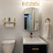 Square frame Modern powder room design with matching gold fixtures