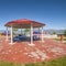 Square frame Octagon shaped picnic pavilion with view of colorful playground and scenic lake