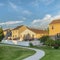 Square frame Pathway on lush green grassy ground in front of houses with balconies and stairs