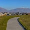 Square frame Paved road on a lush grassy hill overlooking beautiful houses on a sunny day