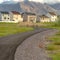 Square frame Road that leads to lovely multi storey homes with mountain in the background