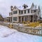 Square frame Row of charming houses with snowy yards inside the wooden fences in winter