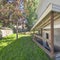 Square frame Separate basement apartment entrance with stairs, glass panel and trees on the lawn at the side