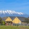 Square frame Single storey houses against striking snow capped mountain and vibrant blue sky