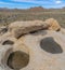 Square frame Three puddles on the rock with a view of a rocky mountains at Joshua Tree National Park, California