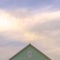 Square frame Top exterior of a house with view of the light green wall and gable vent