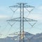 Square frame Towering power lines in the valley against snow capped mountain and blue sky