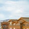 Square frame Upper exterior of houses against snow covered mountain and cloudy sky in winter