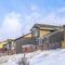 Square frame Wasatch Mountain residential area with homes against clouds and blue sky