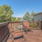 Square frame Wooden balcony with metal armchairs facing the sliding glass door of a home