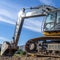 Square frame Yellow excavator with continuous tracks digging soil at a construction site