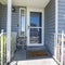 Square Front porch of a house with glass storm door with sidelight