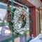 Square Frosted wreath on the glass wall of building that reflects the winter landscape