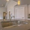 Square Gleaming stainless steel sink and faucet inside the kitchen of a new home