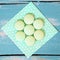 square of green biscuits or cookies on a dotted napkin, blue background