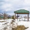 Square Green cabana with barbecue grill and picnic table at a snow covered park
